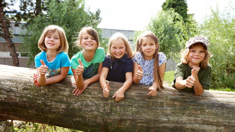 Kinder auf Baumstamm